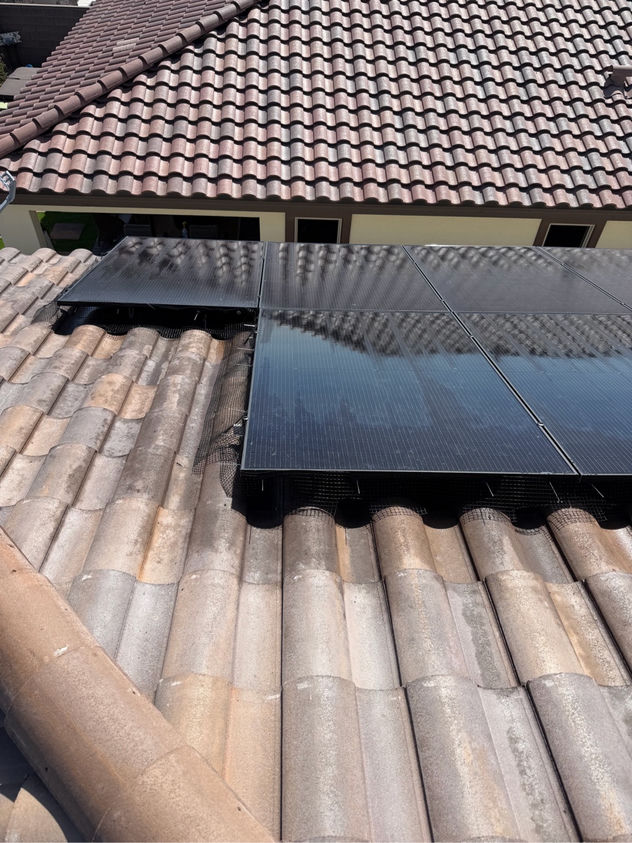 Solar panels on a Las Vegas tile roof after pigeon nest removal and professional critter guard mesh installation
