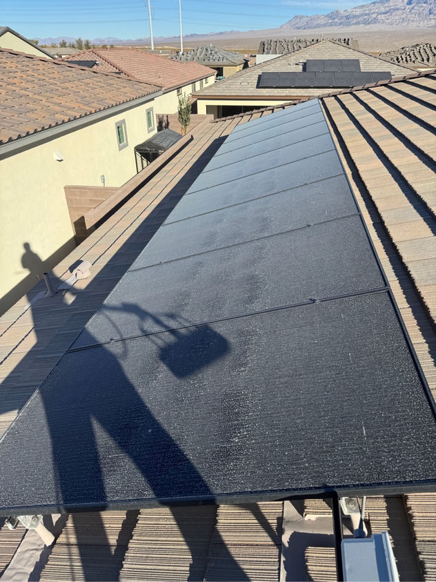 Heavily dust-coated solar panels on a Las Vegas rooftop before professional cleaning — desert grime reduces output by up to 40 percent