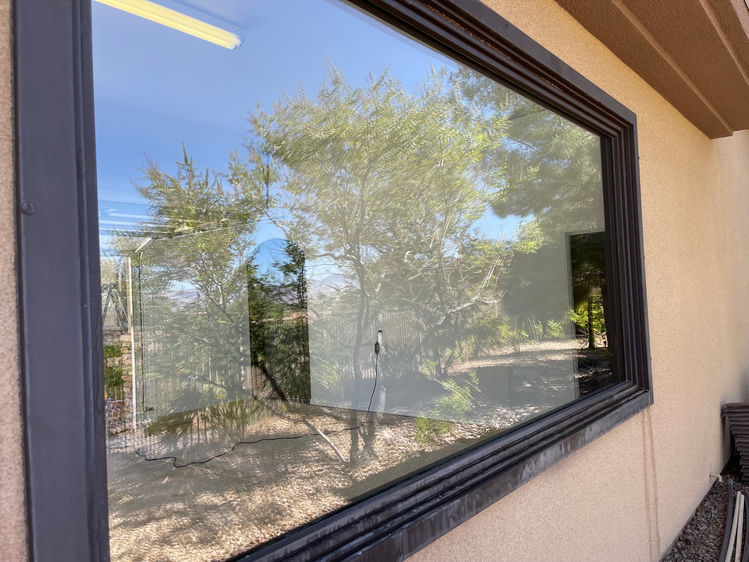 Same large picture window after professional hard water removal — fully clear and reflective
